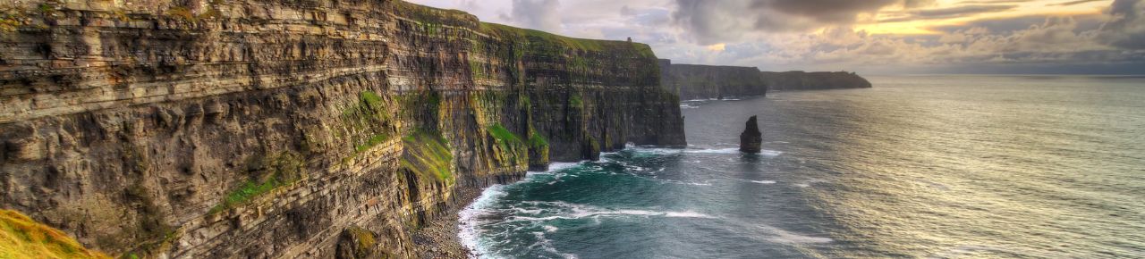 Cliffs of Moher overlooking the ocean with a dramatic sky.