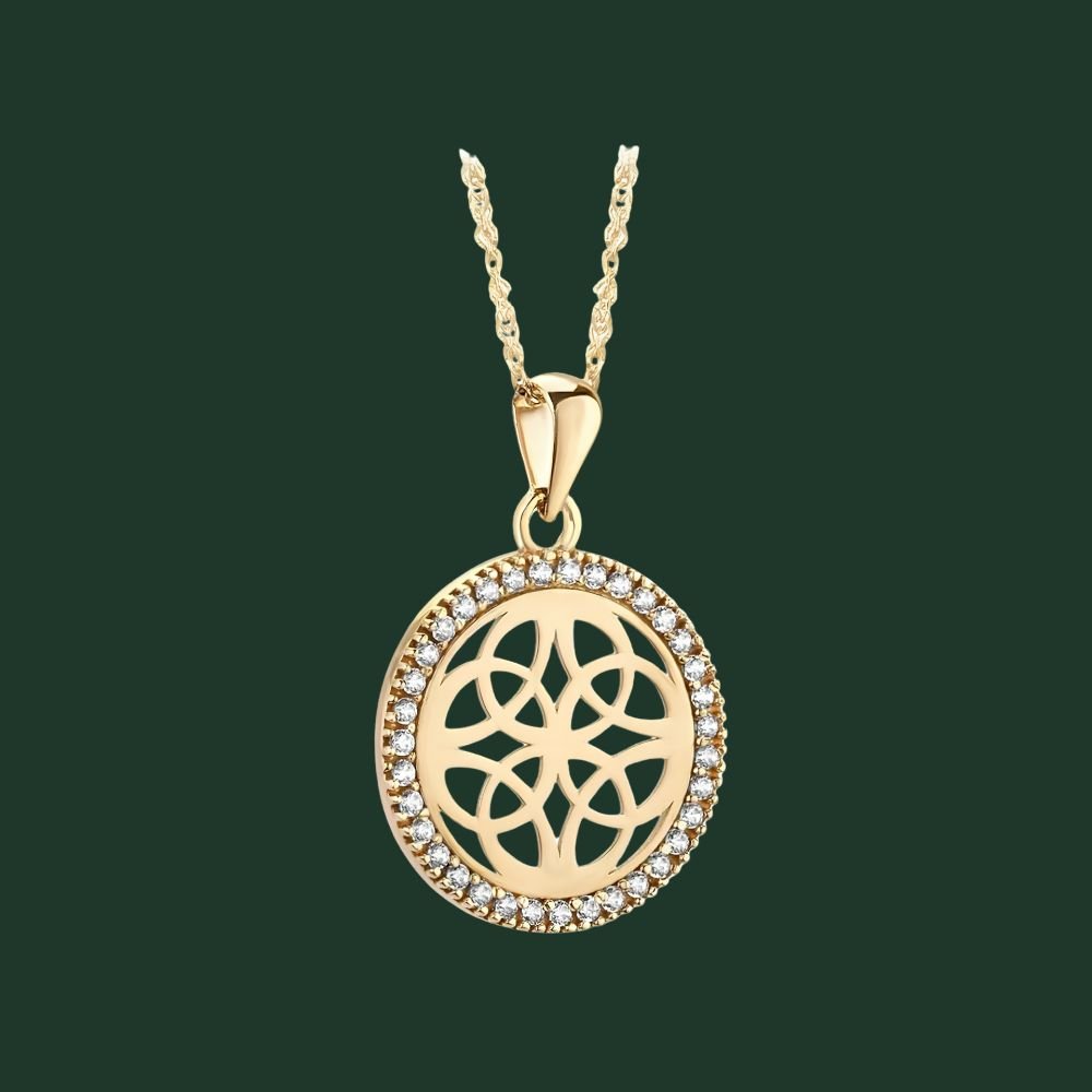 Gold necklace with a circular pendant on a green background