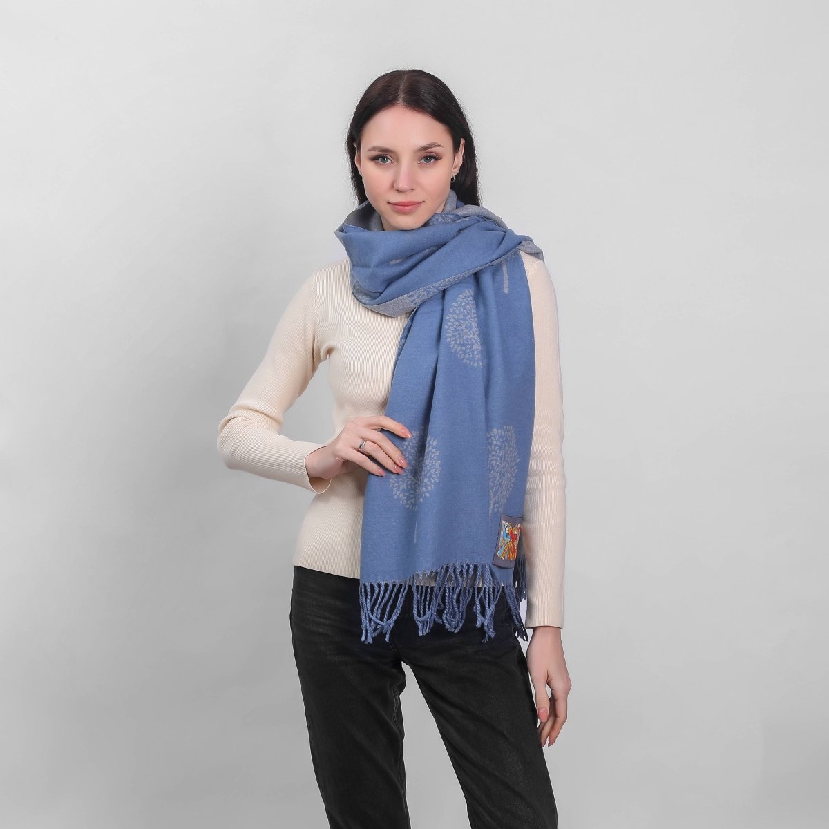 Woman wearing a blue scarf on a plain background