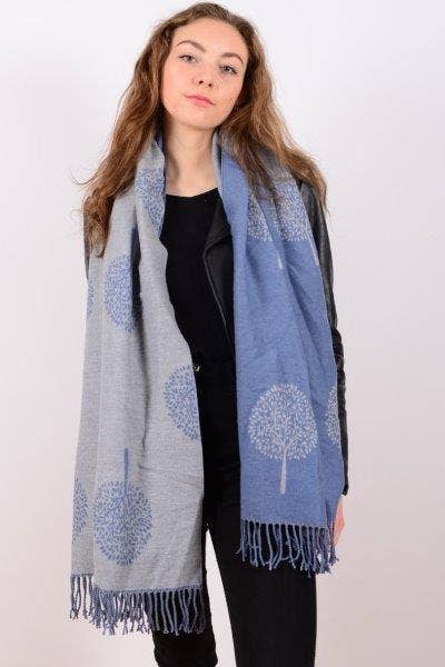 Woman wearing a blue and gray scarf with tree patterns on a white background